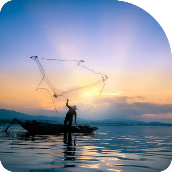 A man standing on a boat holding a fishing net.